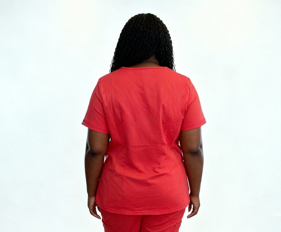 Person wearing a red scrub set against a white background