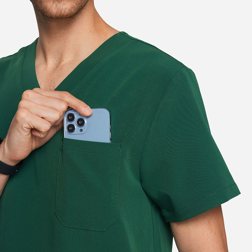 Person wearing green scrubs with a phone in the pocket against a white background