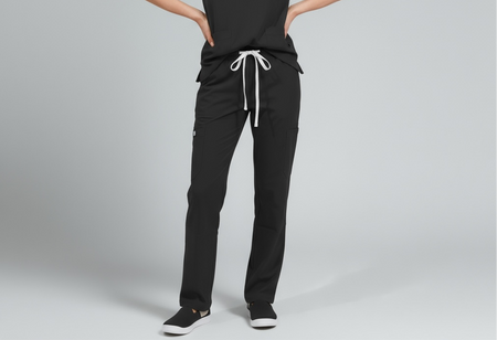 Person wearing black scrubs with white drawstrings on a gray background