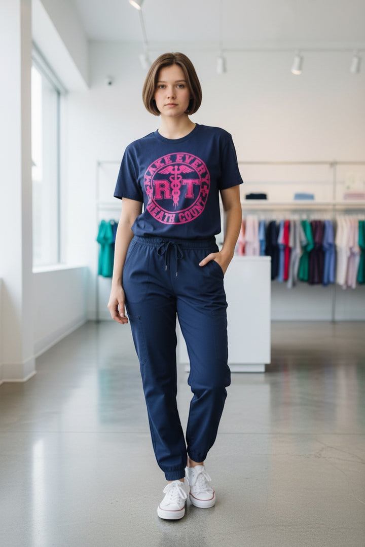 Scrubs Galore Uniforms navy blue 100% cotton RT tee with pink 'Make Every Breath Count' graphic and caduceus symbol.